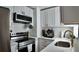 Bright kitchen features quartz countertops, gold hardware, stainless steel appliances, and shaker style cabinets at 2219 Thrace St, Tampa, FL 33605