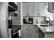 Modern kitchen with stainless steel appliances, white cabinets, granite counters, and hardwood floors at 2219 Thrace St, Tampa, FL 33605
