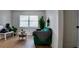 Bright living room featuring a green sofa, a side table, and large window with blinds at 2219 Thrace St, Tampa, FL 33605