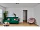 Bright living room with a green sofa, pink pillows, a small table and a pink chair at 2219 Thrace St, Tampa, FL 33605