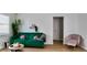 Comfortable living room with a green sofa, decorative pillows, a side table, and a pink chair at 2219 Thrace St, Tampa, FL 33605