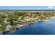 Aerial view of waterfront homes with lake access, featuring lush greenery and clear skies at 22852 Fern Ct, Land O Lakes, FL 34639