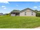 View of the back of a cozy home featuring a screened porch and spacious backyard with lush green grass at 22852 Fern Ct, Land O Lakes, FL 34639