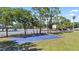 Blue community basketball court, adjacent to playground, surrounded by green space and mature trees at 22852 Fern Ct, Land O Lakes, FL 34639