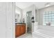 Bright bathroom featuring a tub, shower, and wood vanity with ample storage space at 22852 Fern Ct, Land O Lakes, FL 34639