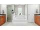 Well-lit bathroom with a soaking tub, glass shower, and wooden cabinets at 22852 Fern Ct, Land O Lakes, FL 34639