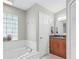 Stylish bathroom with a soaking tub, tiled floors, and wooden cabinets at 22852 Fern Ct, Land O Lakes, FL 34639