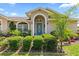 Attractive home entrance with a colorful door, manicured bushes, and a vibrant flowerbed at 22852 Fern Ct, Land O Lakes, FL 34639