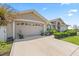 Home exterior featuring a large garage, a beautifully landscaped yard and an inviting front entryway at 22852 Fern Ct, Land O Lakes, FL 34639