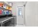 Laundry room with stainless steel appliances, storage shelves, and an exterior door at 22852 Fern Ct, Land O Lakes, FL 34639