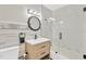 Modern bathroom with patterned tiles, a vanity, and a glass-enclosed shower and tub at 2303 E Osborne Ave, Tampa, FL 33610