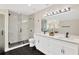 Modern bathroom featuring dual sinks, framed mirrors, a large glass shower with modern tile at 2303 E Osborne Ave, Tampa, FL 33610
