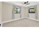 Bright bedroom features two windows dressed with floral curtains and a ceiling fan at 2303 E Osborne Ave, Tampa, FL 33610