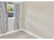 This bright bedroom has light gray wood flooring and floral curtains on the window at 2303 E Osborne Ave, Tampa, FL 33610