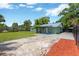 Home's exterior features a driveway and large backyard with a lawn and mulch at 2303 E Osborne Ave, Tampa, FL 33610