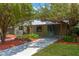 Beautiful home featuring a covered carport, lush landscaping, and a freshly painted exterior at 2303 E Osborne Ave, Tampa, FL 33610