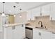 Bright kitchen features white cabinets, modern hardware, stainless steel appliances, and stylish pendant lighting at 2303 E Osborne Ave, Tampa, FL 33610