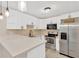 Modern kitchen featuring white cabinetry, stainless steel appliances, and sleek countertops at 2303 E Osborne Ave, Tampa, FL 33610