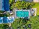 Aerial view of a screened-in pool surrounded by patio, landscaping, lounge chairs, and neighboring houses at 2311 64Th Street W Ct, Bradenton, FL 34209