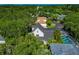 Aerial view of a home showcasing the roof, screened-in patio, and lush surrounding trees at 2311 64Th Street W Ct, Bradenton, FL 34209