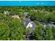Aerial shot of a home surrounded by mature trees, featuring a screened lanai, and lush landscaping at 2311 64Th Street W Ct, Bradenton, FL 34209