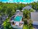 Overhead view of a screened in pool, patio, and landscaping with surrounding trees on a sunny day at 2311 64Th Street W Ct, Bradenton, FL 34209