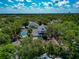 Aerial view of a home with mature trees, highlighting the pool area, screened lanai, and neighborhood at 2311 64Th Street W Ct, Bradenton, FL 34209