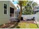 A backyard featuring a screened-in patio, mature tree, and a white picket fence at 2311 64Th Street W Ct, Bradenton, FL 34209
