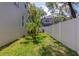 Backyard featuring a white fence, green grass, and well-maintained landscaping at 2311 64Th Street W Ct, Bradenton, FL 34209