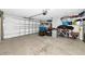 Spacious garage featuring a roll-up door, storage shelves, and ample room for vehicles and storage at 2311 64Th Street W Ct, Bradenton, FL 34209