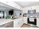Modern kitchen featuring white cabinets, granite countertops, stainless steel appliances, and stylish backsplash at 2311 64Th Street W Ct, Bradenton, FL 34209