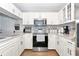 Well-lit kitchen with white cabinets, stainless steel appliances, granite countertops, and a modern backsplash at 2311 64Th Street W Ct, Bradenton, FL 34209