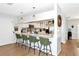 Bright kitchen featuring white cabinets, stainless steel appliances, bar seating, and modern lighting at 2311 64Th Street W Ct, Bradenton, FL 34209