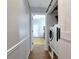 Hall laundry area features a stacked washer and dryer and a sliding barn door, providing convenience and saving space at 2311 64Th Street W Ct, Bradenton, FL 34209