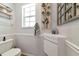 Modern powder room with floating vanity, chrome faucet, unique wall decor, and decorative moldings at 2311 64Th Street W Ct, Bradenton, FL 34209