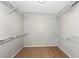 Bright walk-in closet with natural wood flooring and white shelving to maximize storage at 2311 64Th Street W Ct, Bradenton, FL 34209