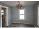Dining room with blue walls, wood-look floors, window, and chandelier at 2326 Melrose S Ave, St Petersburg, FL 33712