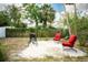 Enjoy the tranquility of this backyard oasis featuring a patio, a grill and two red chairs at 2403 E Osborne Ave, Tampa, FL 33610