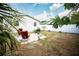 Spacious backyard with a patio, grill, two red chairs and white fence, perfect for outdoor entertaining at 2403 E Osborne Ave, Tampa, FL 33610
