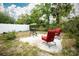 A backyard featuring a patio, grill, and two red chairs, ideal for outdoor gatherings at 2403 E Osborne Ave, Tampa, FL 33610