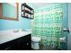 This bathroom features a stylish vanity with a sink and a patterned shower curtain at 2403 E Osborne Ave, Tampa, FL 33610