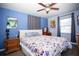 Cozy bedroom with a ceiling fan, blue walls, and a large window at 2403 E Osborne Ave, Tampa, FL 33610