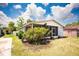 Cozy home featuring a screen porch and beautiful landscaping for a serene outdoor space at 2403 E Osborne Ave, Tampa, FL 33610
