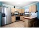 Bright kitchen with stainless steel appliances, wood cabinets, and a breakfast bar at 2403 E Osborne Ave, Tampa, FL 33610