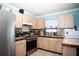 Bright kitchen with stainless steel appliances, wood cabinets, and a breakfast bar at 2403 E Osborne Ave, Tampa, FL 33610