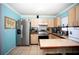 Bright kitchen with stainless steel appliances, wood cabinets, and a breakfast bar at 2403 E Osborne Ave, Tampa, FL 33610