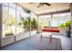 Relaxing screened porch offers a comfortable seating area with a porch swing and outdoor view at 2403 E Osborne Ave, Tampa, FL 33610