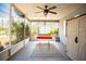 Inviting screened porch features a swing, ceiling fan, and views of the outdoors at 2403 E Osborne Ave, Tampa, FL 33610