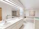 Bright and spacious main bathroom featuring double sinks, a bathtub, and elegant decor at 2517 Bucknell Dr, Valrico, FL 33596