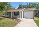 Beautiful house featuring lush lawn, attached garage, landscaping, and a freshly painted facade at 2613 E 113Th Ave, Tampa, FL 33612